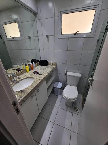 a bathroom with a toilet and a sink and a window at CONDOMÍNIO VERANO APTO 1206 PONTA NEGRA RN in Natal