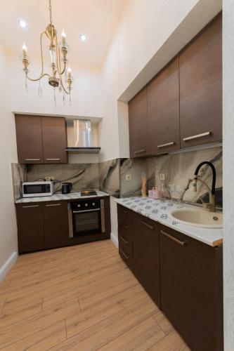 a kitchen with brown cabinets and a sink at Marita Hotel in Tbilisi City