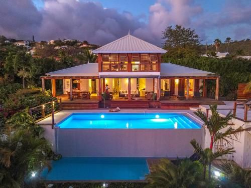ein Haus mit Pool davor in der Unterkunft Villa Caraïbe in Case-Pilote