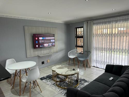a living room with a couch and tables and a tv at Beautiful 2 bedroom apartment In Richard's bay in Richards Bay