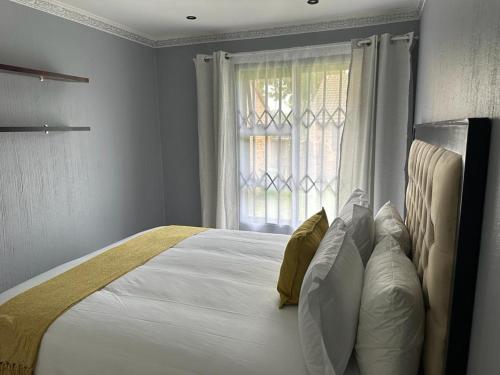 a bedroom with a large white bed with a window at Beautiful 2 bedroom apartment In Richard's bay in Richards Bay