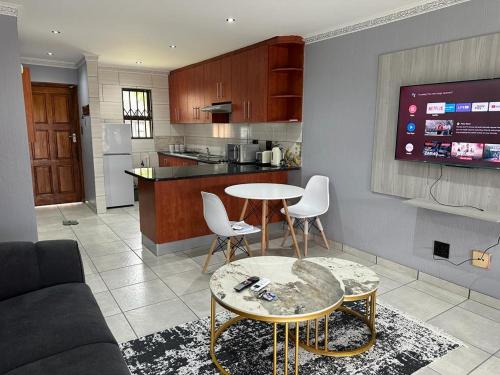 a kitchen and living room with a table and chairs at Beautiful 2 bedroom apartment In Richard's bay in Richards Bay