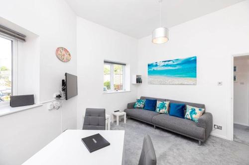 a living room with a couch and a table at Bournecoast: Patio Garden - Parking - WIFI -FM8455 in Bournemouth