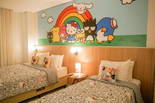 a bedroom with two beds and a rainbow on the wall at Trento Hotel Guaíra by Unna in Guaíra