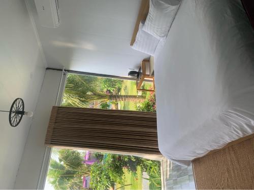 Un dormitorio con una cama y una ventana con un ciego en Nhật Hạ Villa en Tam Hà