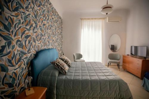 een slaapkamer met een bed met een blauw hoofdeinde bij GARRUBA House in Bari