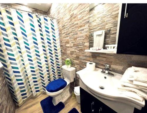uma casa de banho com um WC azul e um lavatório. em JC caribe Aparta Hotel #7 em Boca Chica