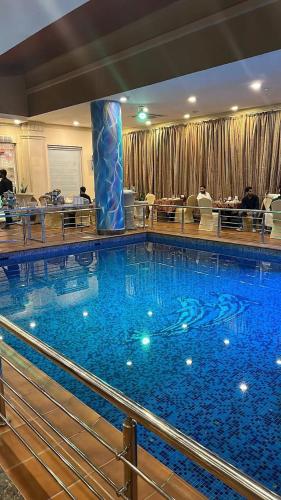 a large blue swimming pool in a building at فندق كارم العليا in Al Khobar