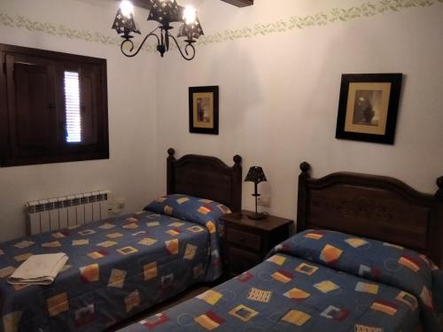 Pina de Montolgrao的住宿－Casa la Cisterna，一间卧室设有两张单人床和一个窗户。