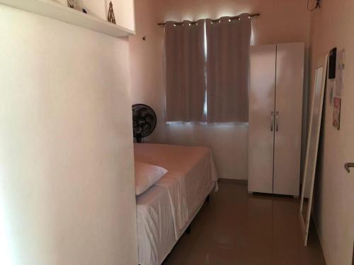 een kleine slaapkamer met een bed en een koelkast bij Casa e suítes da Vava in Trairi