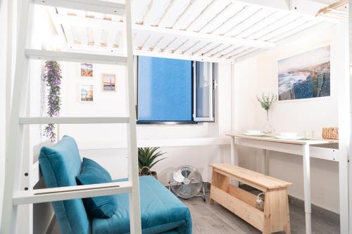 リスボンにあるEstrela Apartmentの二段ベッド1組と青い椅子が備わる客室です。