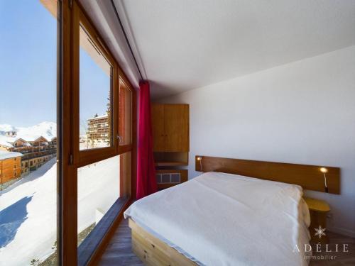 een slaapkamer met een bed en een groot raam bij Appartement 2 Pièces - Balcon Ouest, Proche Pistes et Commerces - 4 Pers, 2* - FR-1-398-516 in La Rosière