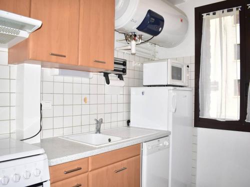 een keuken met een wastafel en een witte koelkast bij Appartement Font-Romeu-Odeillo-Via, 2 pièces, 4 personnes - FR-1-580-41 in Font Romeu Odeillo Via