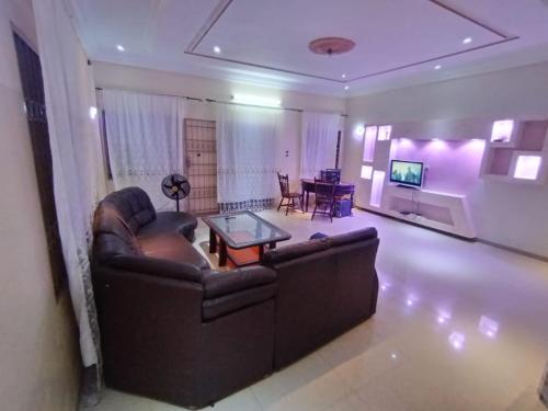 a living room with a couch and a table at Chambre privée pavé kérékou calavie in Abomey-Calavi