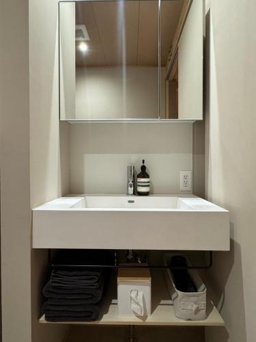 直島町にあるARTISANALのバスルーム(白い洗面台、鏡付)