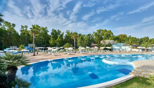 una gran piscina con sillas y sombrillas en Serenè Resort en Steccato