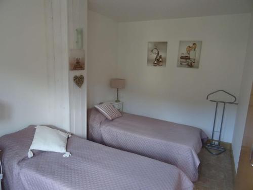 2 camas en una habitación con paredes blancas en Appartement Amélie-les-Bains-Palalda, 2 pièces, 2 personnes - FR-1-659-78, en Amélie-les-Bains-Palalda