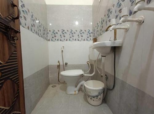 a bathroom with a toilet and a sink at Hotel The Ramam in Ayodhya
