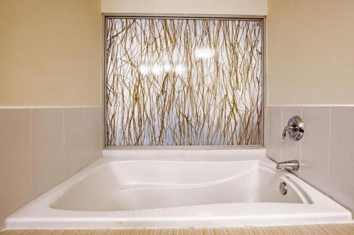 baño con bañera blanca y ventana en Studio Coliving Hotel, en Panamá