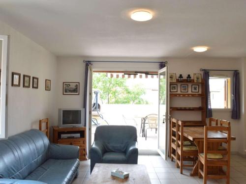 un salon avec un canapé, une table et une télévision dans l'établissement Maison à Narbonne Plage, 3 pièces, 5 couchages, à 300m de la plage avec terrasse et barbecue - FR-1-229B-40, à Narbonne