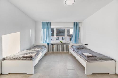 two beds in a room with a window at MONTEURWOHNUNG Ebersbach EB03 RAUMSCHMIDE Apartments in Ebersbach an der Fils