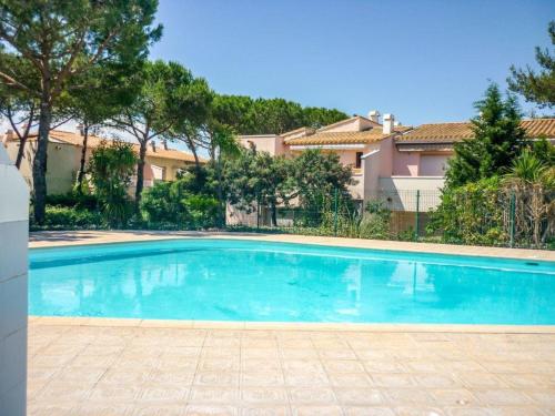une grande piscine bleue devant un immeuble dans l'établissement Superbe T2 avec piscine, parking privé et terrasse, proche du village naturiste et du port - FR-1-749-17, au Cap d'Agde