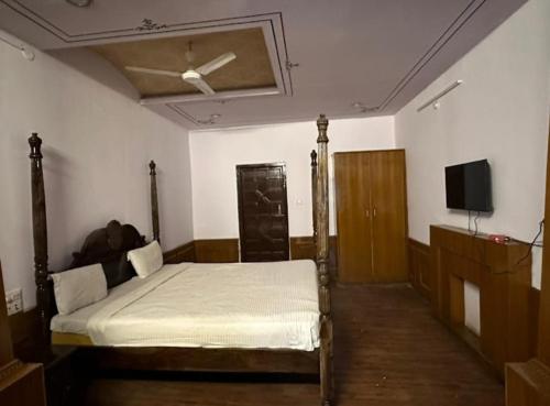 1 dormitorio con 1 cama y ventilador de techo en Hotel the ishani palace en Udaipur