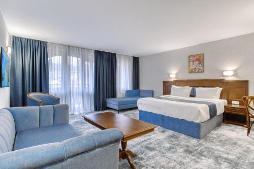 バンスコにあるMPM Hotel Sport Ski-in, Ski-outのベッドとソファ付きのホテルルーム
