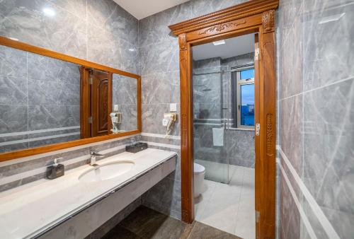 a bathroom with a sink and a mirror and a toilet at Royal Palace in Da Lat