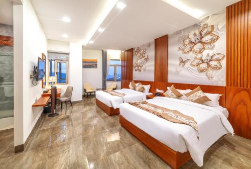 a hotel room with two beds and a desk at Royal Palace in Da Lat