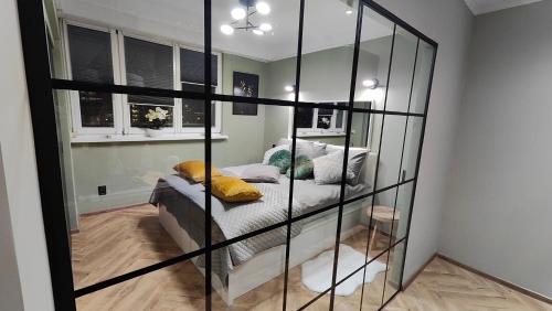 a room with a glass partition with a bed in it at Apartament Korfantego 30 in Katowice