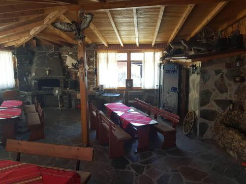 ein Esszimmer mit Tischen und Stühlen in einem Gebäude in der Unterkunft Къща за гости с механа Баджо in Dospat