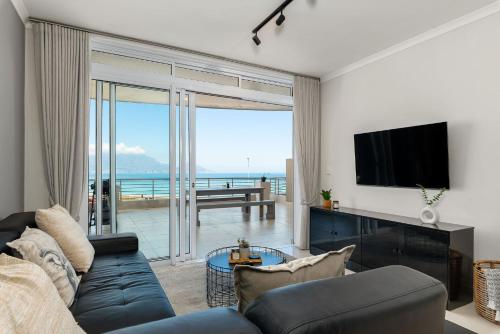 a living room with a couch and a tv at Portico in Bloubergstrand