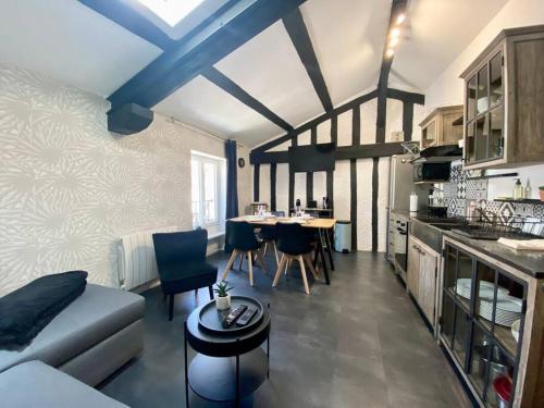 une cuisine et un salon avec un canapé et une table dans l'établissement Bel appartement - 2 chambres - Proche du vieux marché, à La Rochelle