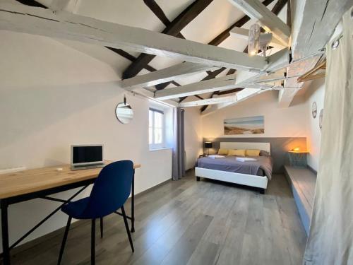 une chambre avec un lit et un bureau avec un ordinateur dans l'établissement Bel appartement - 2 chambres - Proche du vieux marché, à La Rochelle