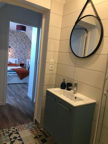 a bathroom with a sink and a mirror on the wall at Grand gîte de la Ferme De La Tourelle in Longues-sur-Mer