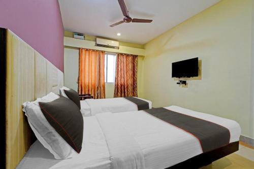 a hotel room with two beds and a flat screen tv at Cedar by K Hotels in Kāndūr