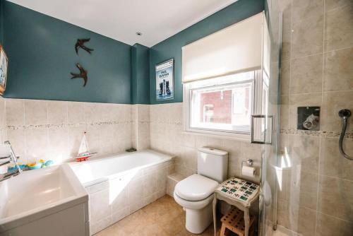 ein Badezimmer mit einer Badewanne, einem WC und einem Waschbecken in der Unterkunft 29 Wentworth Road, Aldeburgh in Aldeburgh