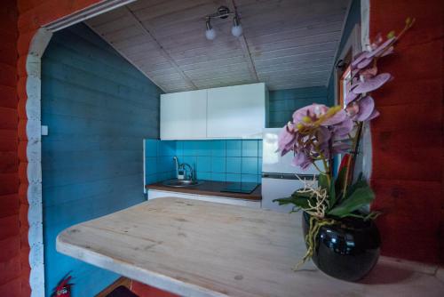 a kitchen with a table with a vase of flowers at Domki Kątno in Stare Jabłonki