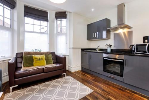 a living room with a couch and a kitchen at Clearly Apartments Bootham York in York