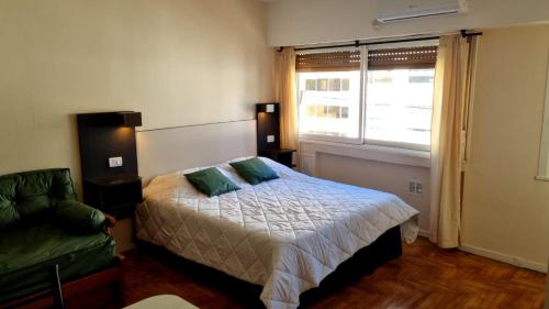 - une chambre avec un lit, un canapé et une fenêtre dans l'établissement Departamento mejor ubicación Buenos Aires, à Buenos Aires
