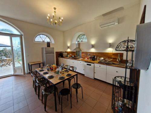 une cuisine avec une table et des chaises dans une pièce dans l'établissement VILLA BELVEDERE D'AJACCIO, VILLA ENTIERE VUE MER POUR 2 à 10 VOYAGEURS, à Ajaccio