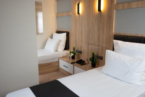 a hotel room with two beds and a desk at Golden River Hotel By Continent in Arnavutköy