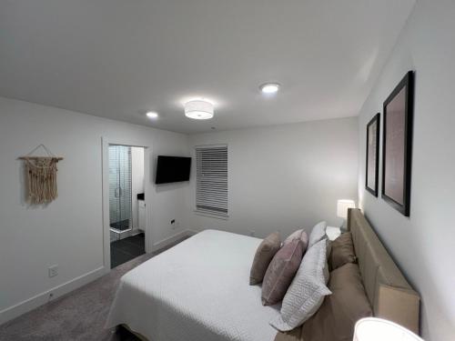 een witte slaapkamer met een bed en een bank bij Closetobroadwayairportoprymillsgameroom in Nashville