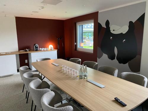a conference room with a wooden table and chairs at Everness Hotel & Resort in Chavannes-de-Bogis