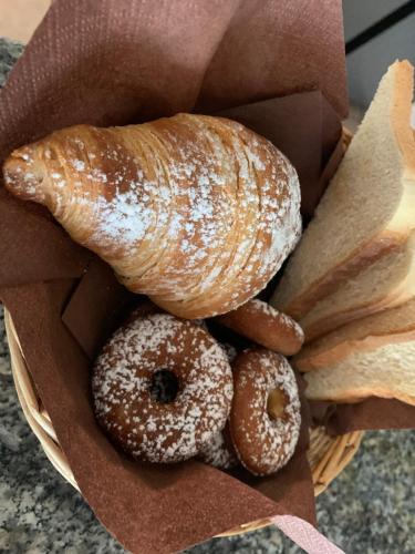 een mand donuts en gebak op een tafel bij Villa Anastasia in Cugnana