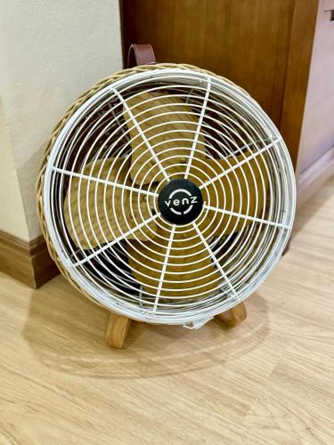 a white fan sitting on top of a wooden floor at L’Oasis Nanai in Patong Beach