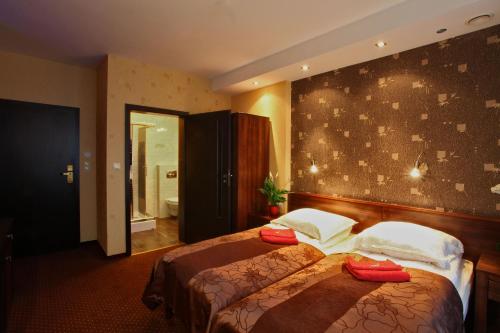 a hotel room with two beds and a bathroom at Willa Magnolia in Gdynia