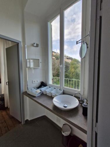 łazienka z umywalką i dużym oknem w obiekcie VILLA BELVEDERE D'AJACCIO, VILLA ENTIERE VUE MER POUR 2 à 10 VOYAGEURS w Ajaccio
