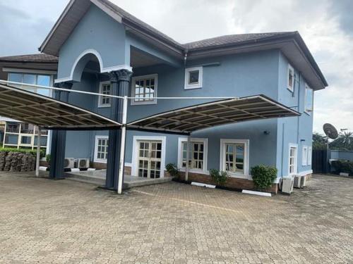 a large blue house with a large patio at BELIANA SUITES in Uyo